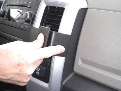 En hand justerar en del i en bilinteriör av Dodge Ram 09-12.