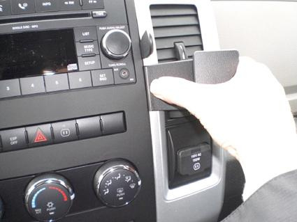 En hand fäster en komponent i interiören av en Dodge Ram 09-12.