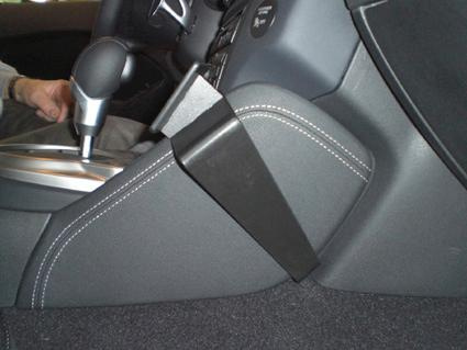 Bilden visar en del av interiören i en Nissan 370Z, med fokus på mittkonsolen.