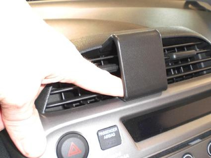 En hand trycker på en luftventil i en Honda Fit/Jazz.