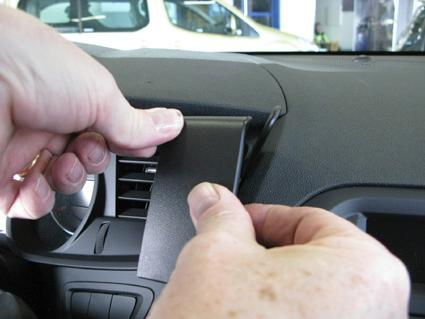 En person installerar en del på instrumentbrädan i en Citroen C5 III.