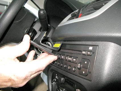 En hand justerar kontroller på en bils mittkonsol.