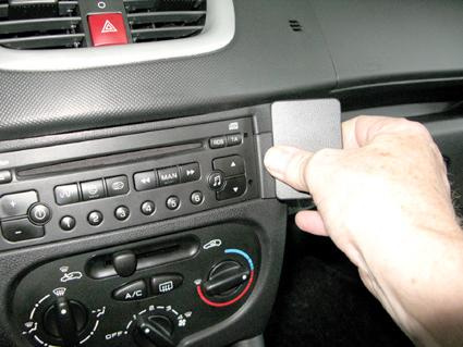 Hand som justerar kontroller i en bilinteriör, Peugeot 206+.