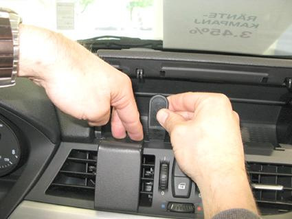 En person installerar en komponent i instrumentbrädan på en BMW Z4.