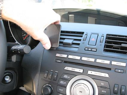 En hand som justerar luftventilen på en Mazda 3-instrumentbräda.