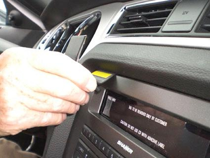 En hand som justerar en del på instrumentbrädan i en Ford Mustang.