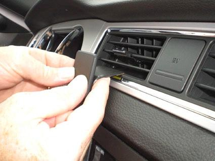 En hand installerar en komponent i luftventilen på en Ford Mustang.