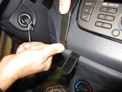 Visar hand som håller i en del av instrumentpanelen i en Ford Transit Connect.