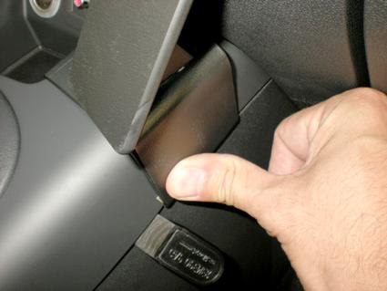 En hand trycker på en knapp eller spak i en bilinteriör.