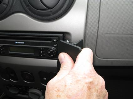 En hand som justerar stereon i en bilinteriör.
