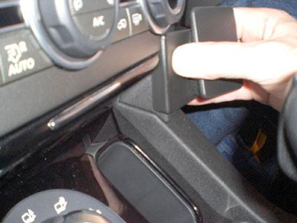 En hand justerar en del av instrumentbrädan i en Landrover Discovery.