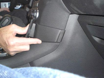 En hand pekar på en del av interiören i en Land Rover Discovery.