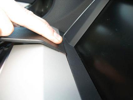 En hand trycker på en del av interiören nära en skärm i en BMW.