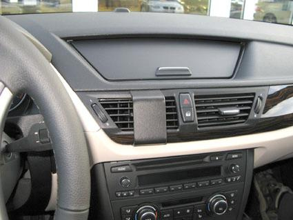 Inre av en bil med instrumentbräda och kontroller för ljud och ventilation.