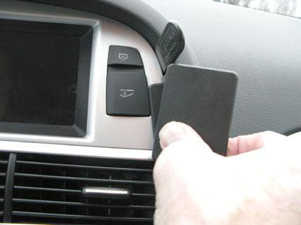 En hand håller en svart kortplats i en Audi A6.