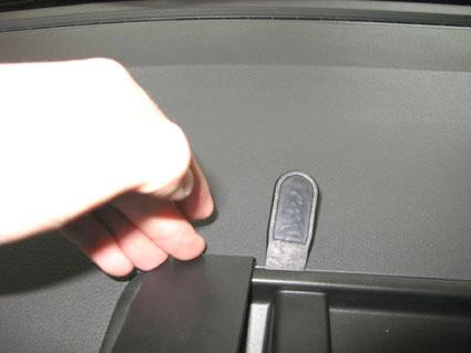 Hand som interagerar med en knapp på en bilinteriör.