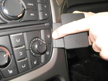 En hand trycker på en kontrollknapp i en bilinterior.