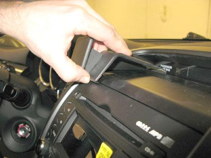 En hand justerar en panel på instrumentbrädan i en Kia Sorento.