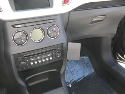 Bilinteriör med kontrollpanel, radio och luftkonditionering.