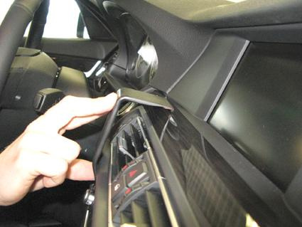 En hand som justerar kontroller på BMW 5:s instrumentbräda.