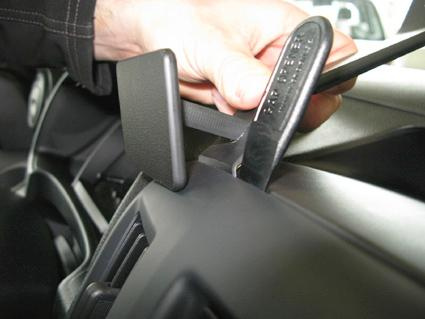 En hand som justerar en kontroll eller del i en Nissan NV200.