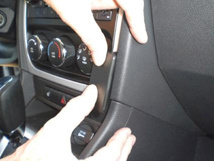 En person installerar en del i interiören av en bil, Dodge Caliber.