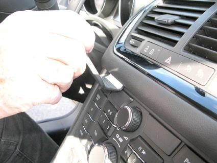 En hand använder ett verktyg för att justera bilen inuti.