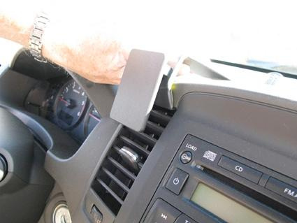 En hand justerar en del av dashboarden i en Nissan Navara.