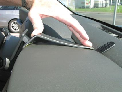 En hand visar en detalj på instrumentpanelen i en Nissan Navara.