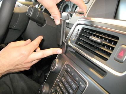 En person justerar en del av instrumentbrädan i en Volvo S60.