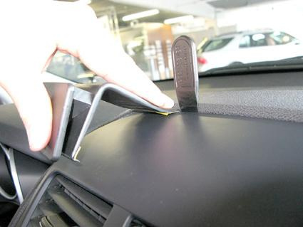 En hand trycker ner en del av instrumentpanelen på Citroen C4 Aircross.