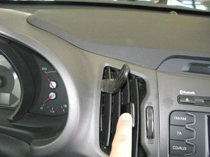 Luftutlopp och kontroller i Kia Sportage, med en hand som justerar ventilationsöppningen.