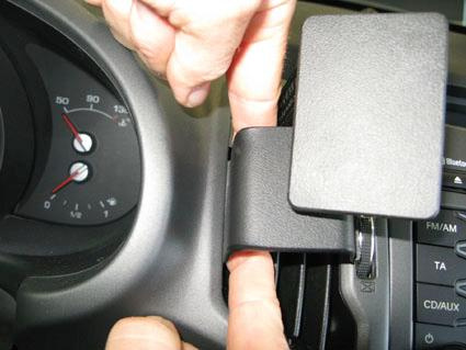 En hand placerar en del på bilens instrumentbräda.