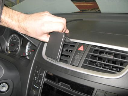 Hand som håller en enhet framför luftventiler i en Suzuki Swift.