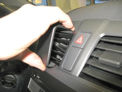 En hand justerar luftöppningen i en Suzuki SX4-interiör.