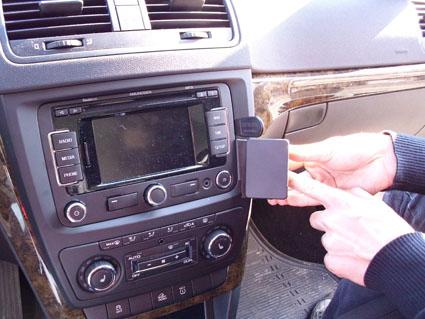 En person installerar en enhet i bilens instrumentpanel.