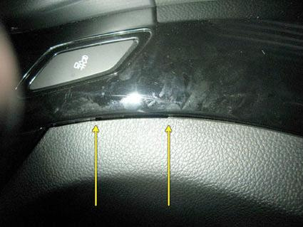 Svart plastpanel med knappar och en lätt struktur.