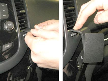 En person installerar en modul i en bils instrumentpanel.