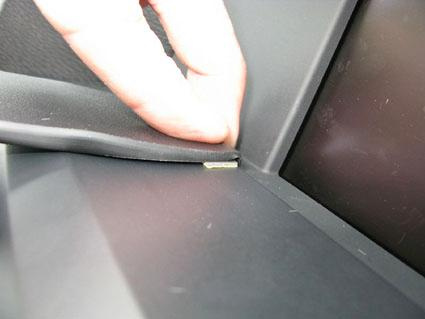 En hand fäster något vid bilens instrumentbräda.