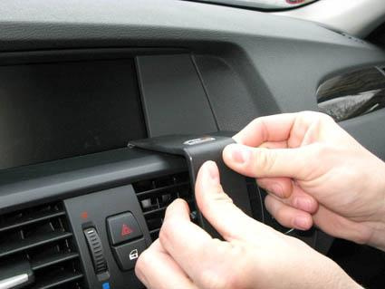 En person monterar en del på en bilinteriör.