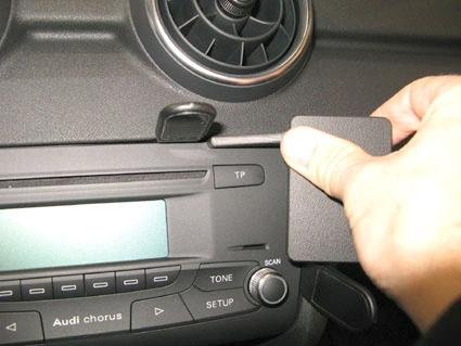 Bilden visar en hand som justerar en del av Audi A1:s kontrollpanel.