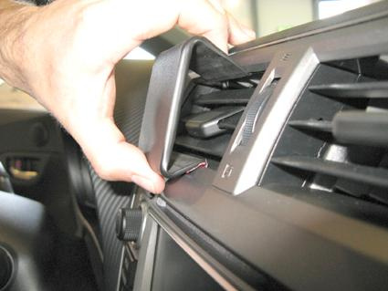 Hand som justerar en del av luftutblåset i en bilinteriör.