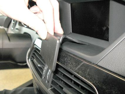 En hand justerar en del i en bilinteriör, specifikt en Mercedes Benz C-Klass.