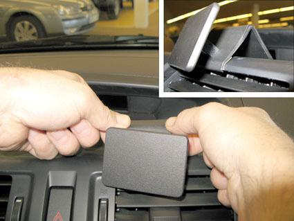 En hand håller i en del som monteras på instrumentpanelen i en Mazda 5.