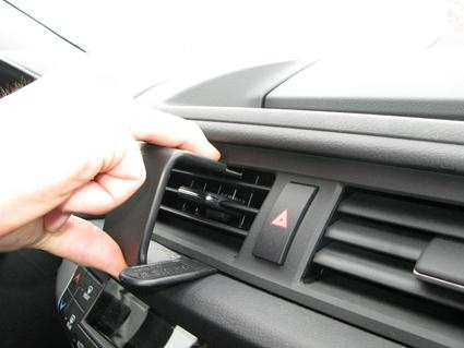 En hand justerar luftventilen i en bilinteriör.
