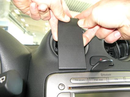 Hand som tar bort ett element från instrumentpanelen i en Nissan Micra.