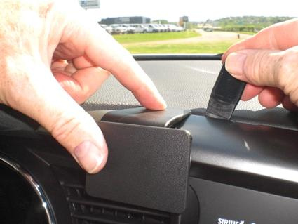 Två händer som installerar en del på instrumentbrädan i en Kia Optima.