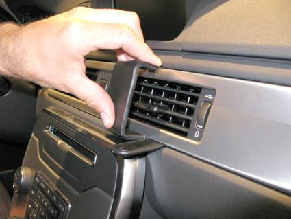 En hand justerar luftventilen i en Volvo V70 interiör.