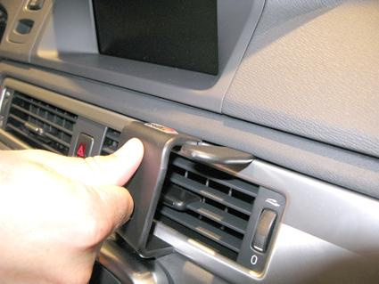 Visa en hand som justerar luftventilen i en Volvo V70.