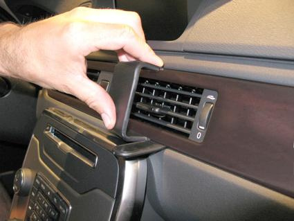 Hand som tar bort en panelventil i en Volvo V70 interiör.